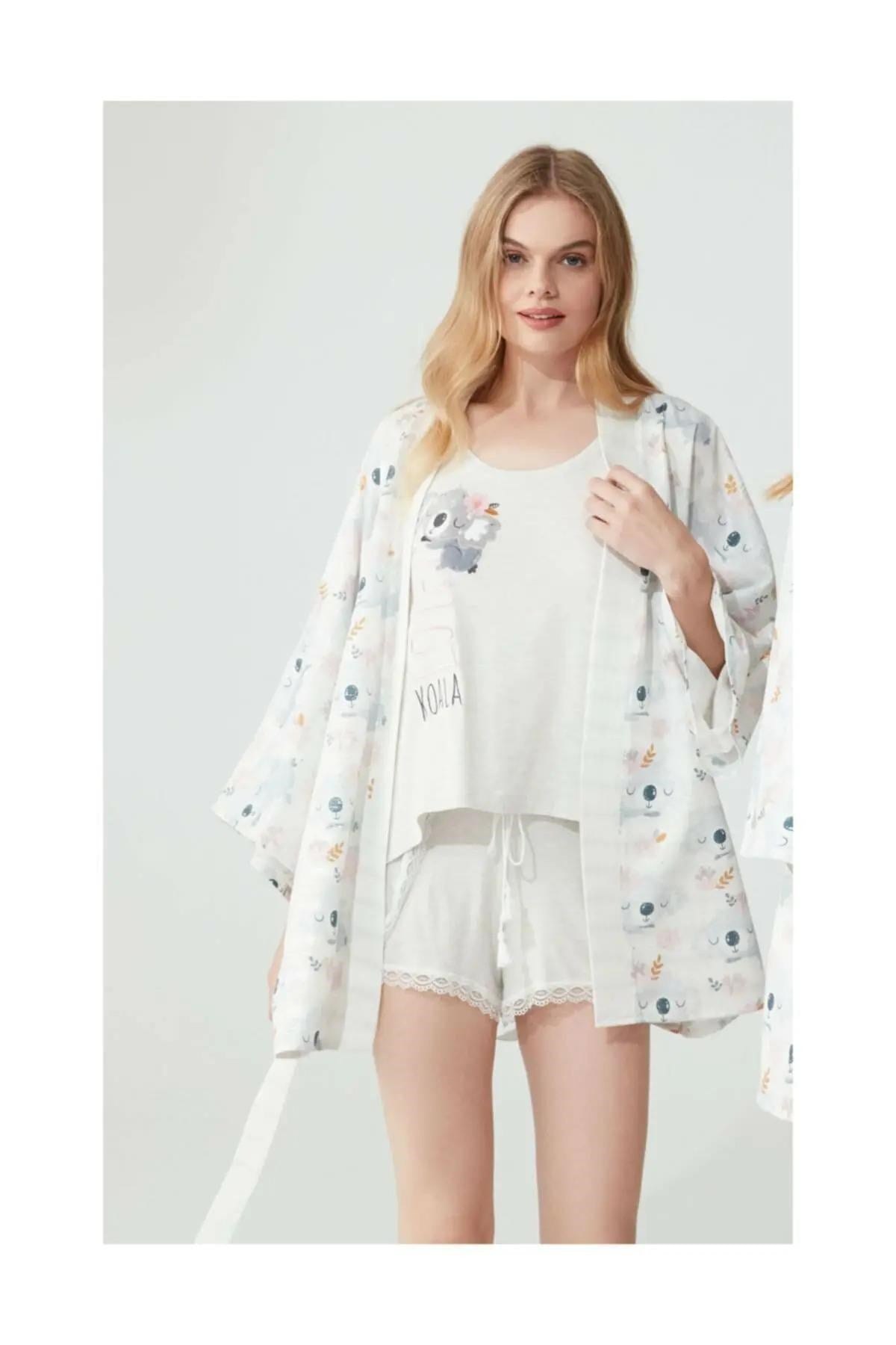 Woman wearing Popjammies' Koala-themed pyjama set, featuring a sleeveless top, matching shorts with lace trim, and a coordinating robe, all adorned with a cute koala print.