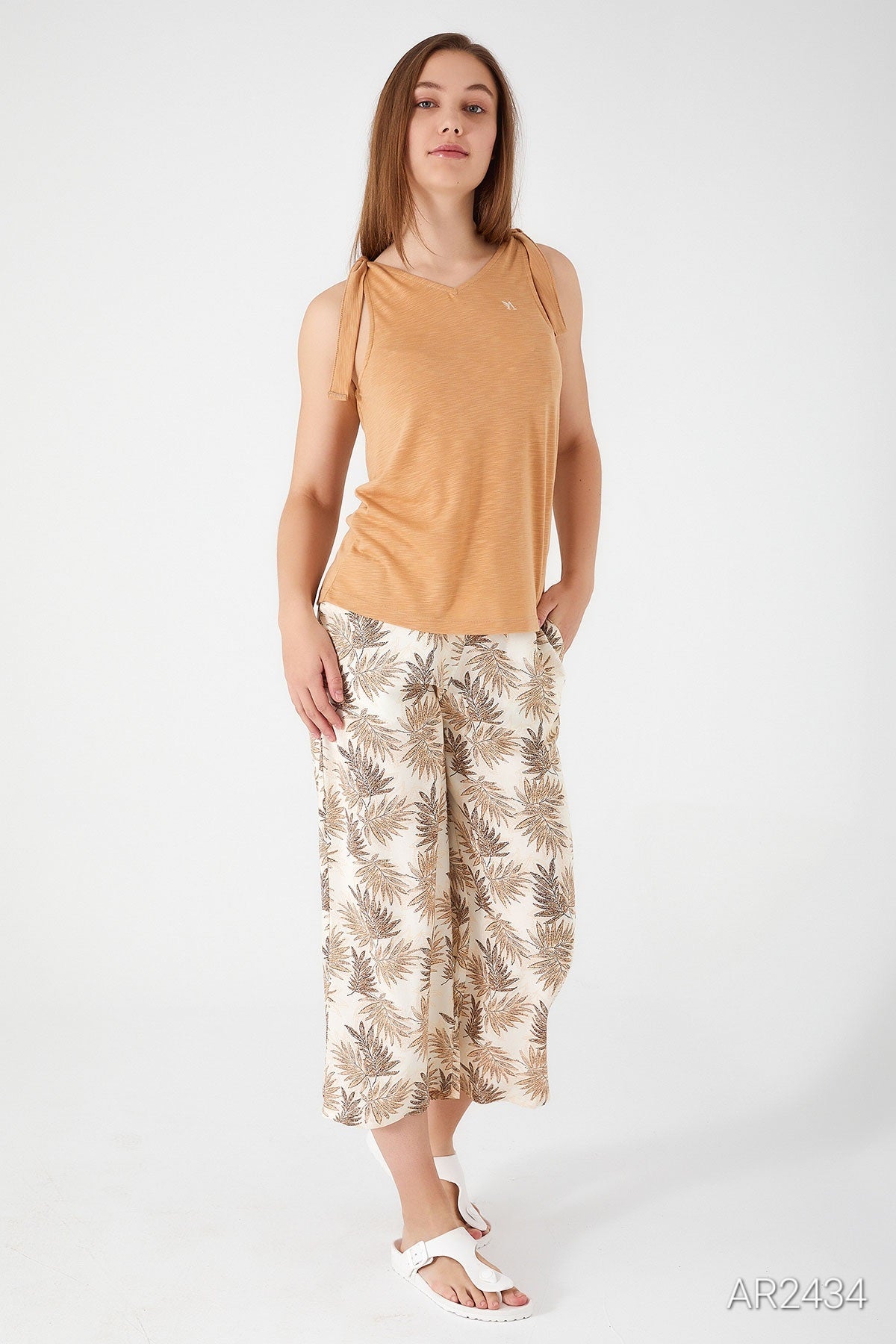 Front view of a model showcasing the Popjammies beige sleeveless pyjama set with floral-patterned pants.