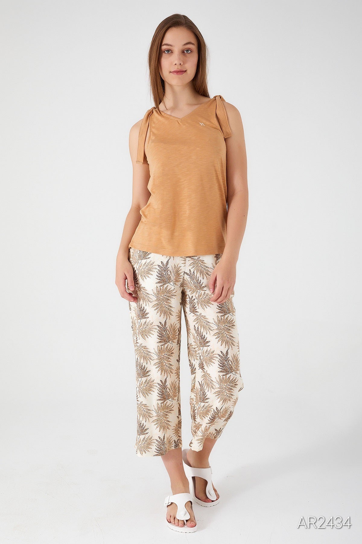 Front view of a model wearing the Popjammies beige sleeveless pyjama set with floral-patterned pants.