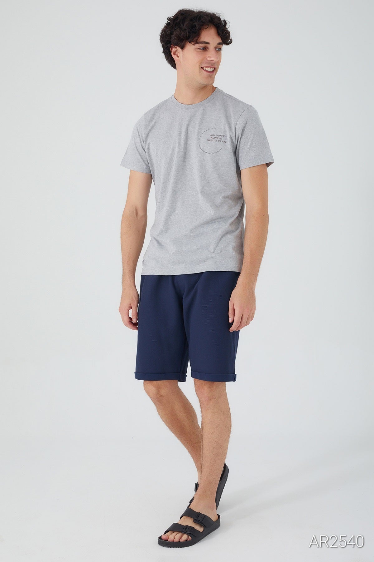 Model wearing the Popjammies Men's Pajama Set with a grey T-shirt and blue shorts, showcasing the comfortable fit.