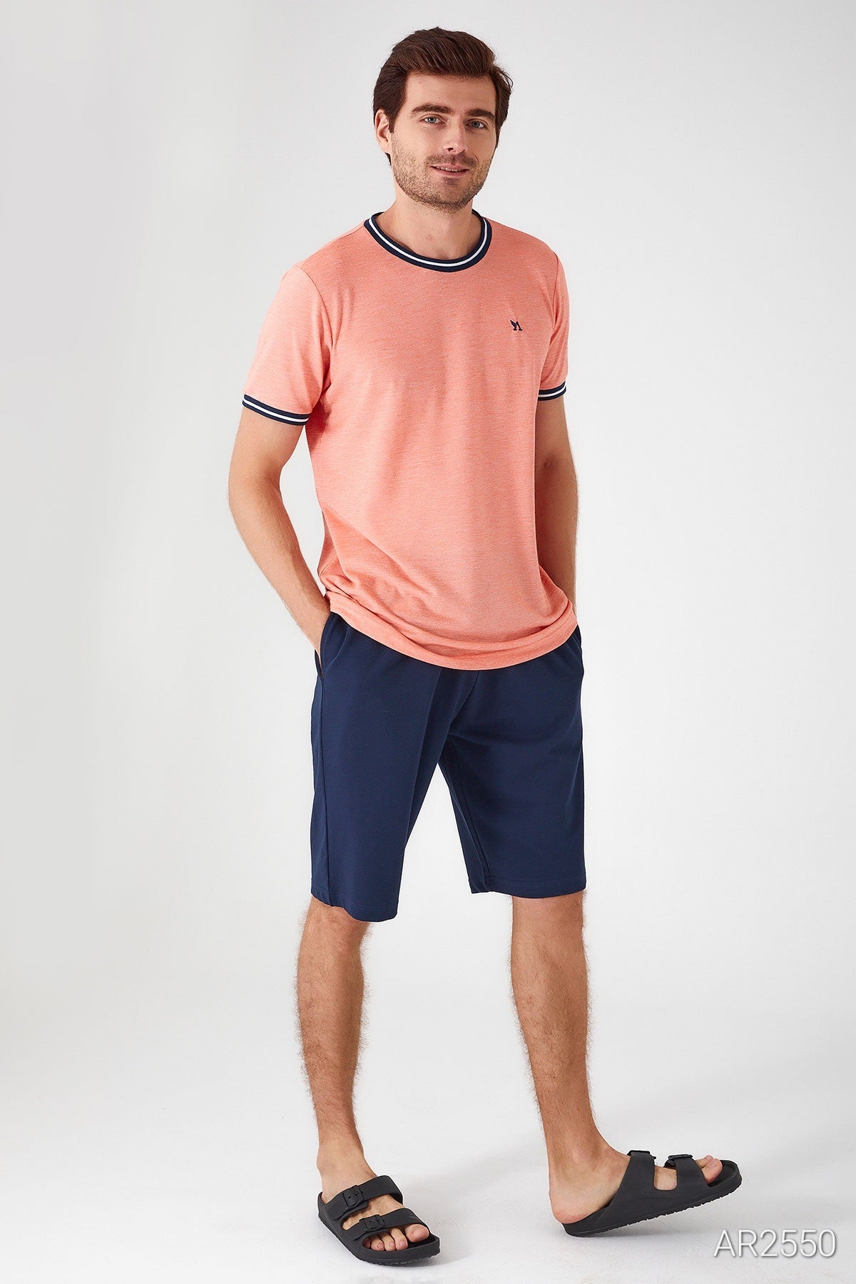 Side view of the man wearing Popjammies pyjama set, showcasing the vibrant orange top and comfortable fit of the blue shorts.