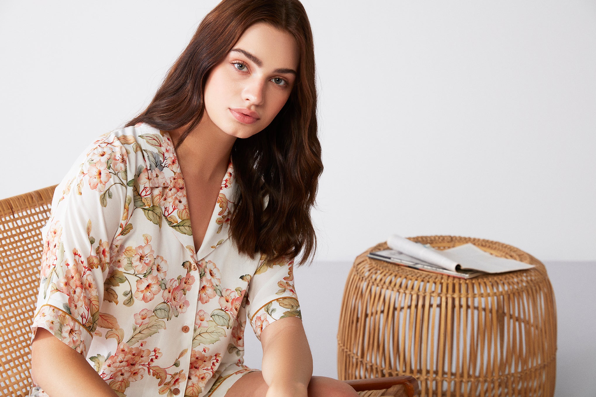 Close-up of a woman wearing a Floral Bliss Short Sleeve Pyjama Set from Popjammies, showcasing the floral design and button-down top