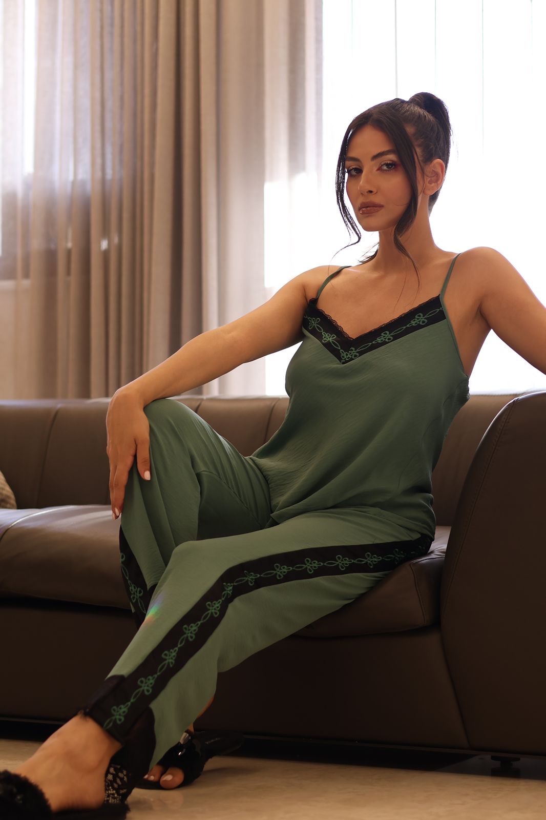 Woman wearing a green Popjammies Pajama Set with a camisole top and matching pants, featuring lace detailing.