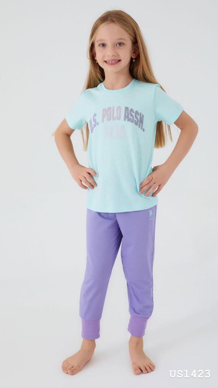 Child wearing the Popjammies Aqua Dream Pajama Set, featuring a soft aqua blue T-shirt with a "U.S. Polo Assn. 1890" graphic and cozy lavender jogger pants, smiling and looking comfortable.