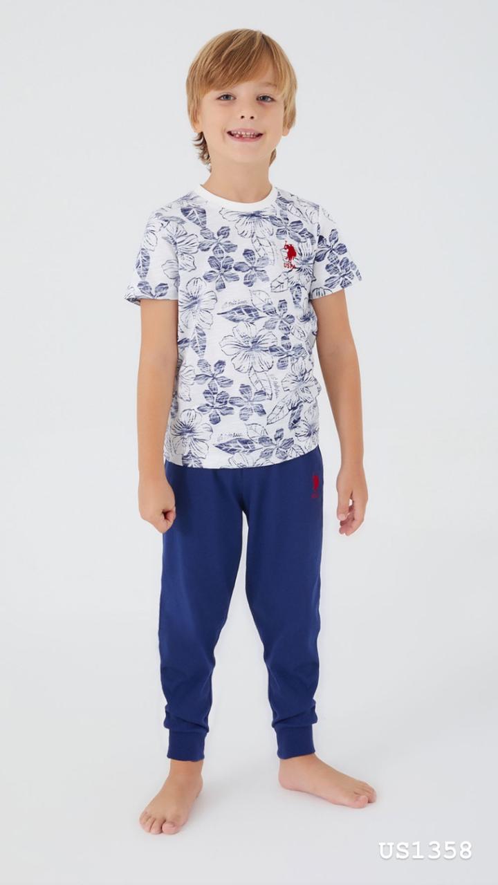 Boy wearing Popjammies floral print pyjama set with white top and navy blue pants, smiling.