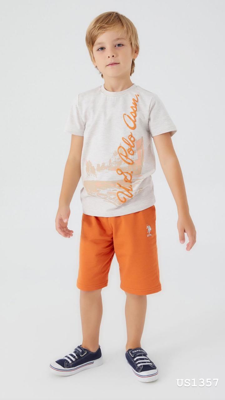 Boy wearing Popjammies sunset city print pyjama set with grey top and orange shorts, smiling.