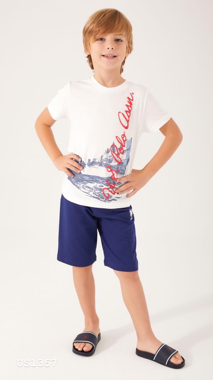 Boy wearing Popjammies nautical print pyjama set with white top and navy blue shorts, smiling.