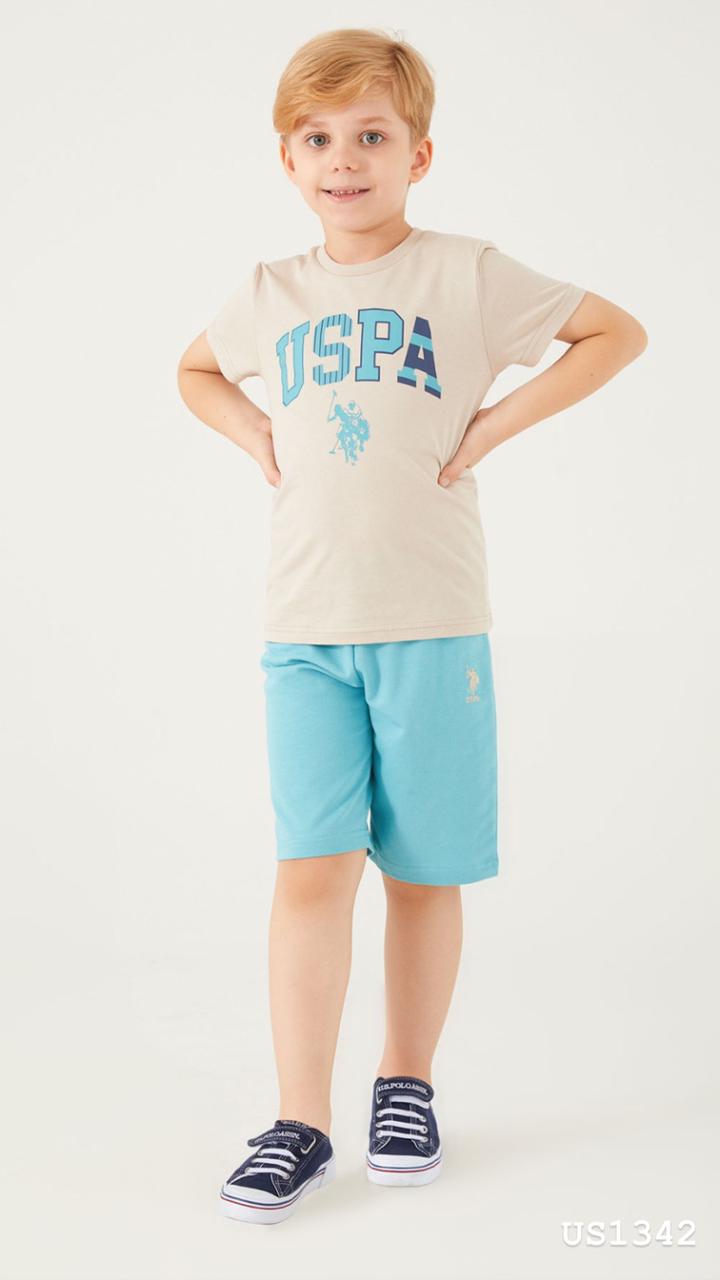 Boy wearing a beige t-shirt with a blue USPA logo and light blue shorts from Popjammies pyjama set.