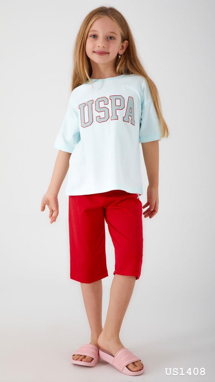 Smiling girl wearing a light blue pyjama top with a bold red 'USPA' logo and bright red shorts from Popjammies.