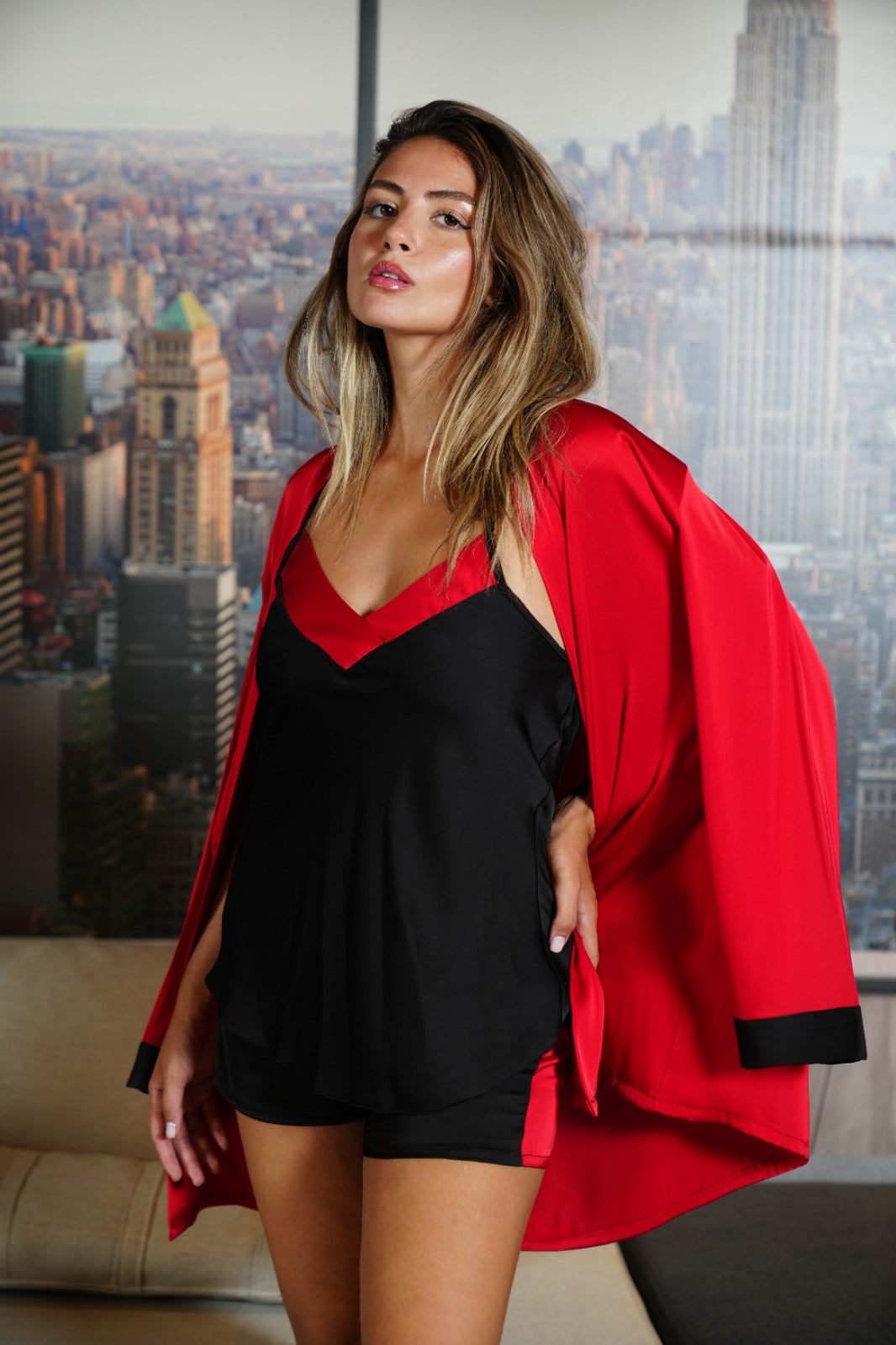  Model in black and red satin pajama set seated, highlighting the comfortable fit and luxurious feel.