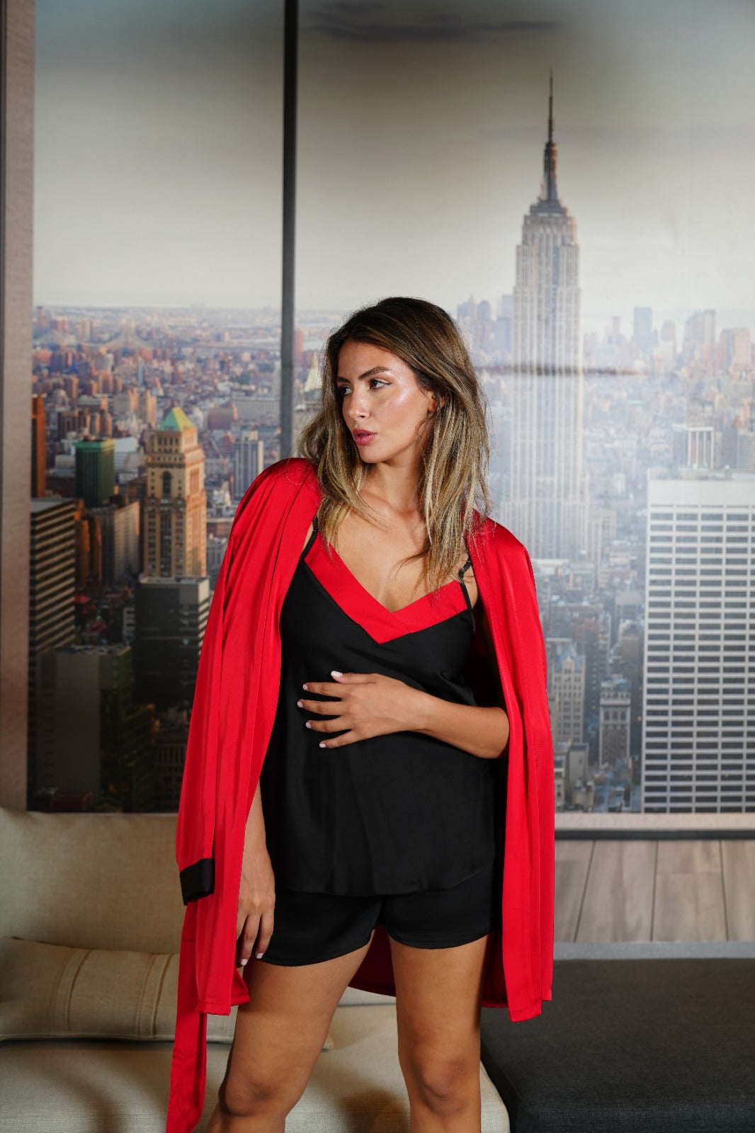 Model standing in a black and red satin pajama set by Popjammies, demonstrating the chic design and matching robe.