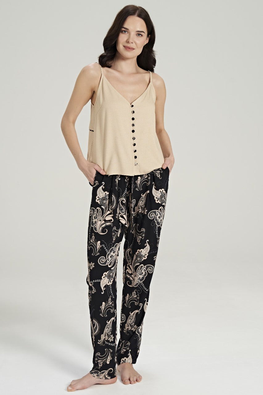  Model wearing a beige buttoned top with black paisley-patterned pants from Popjammies, posing with hands in pockets.