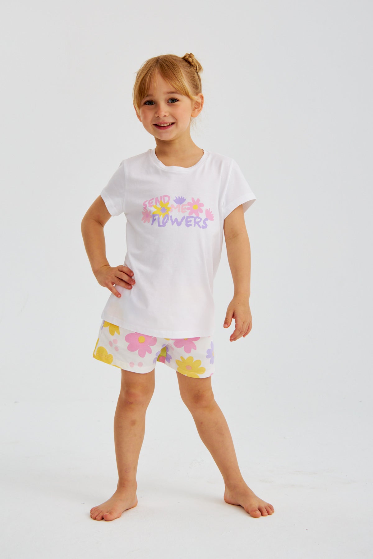 Young girl in the Popjammies "Send Me Flowers" pajama set, smiling with her hands on her hips.