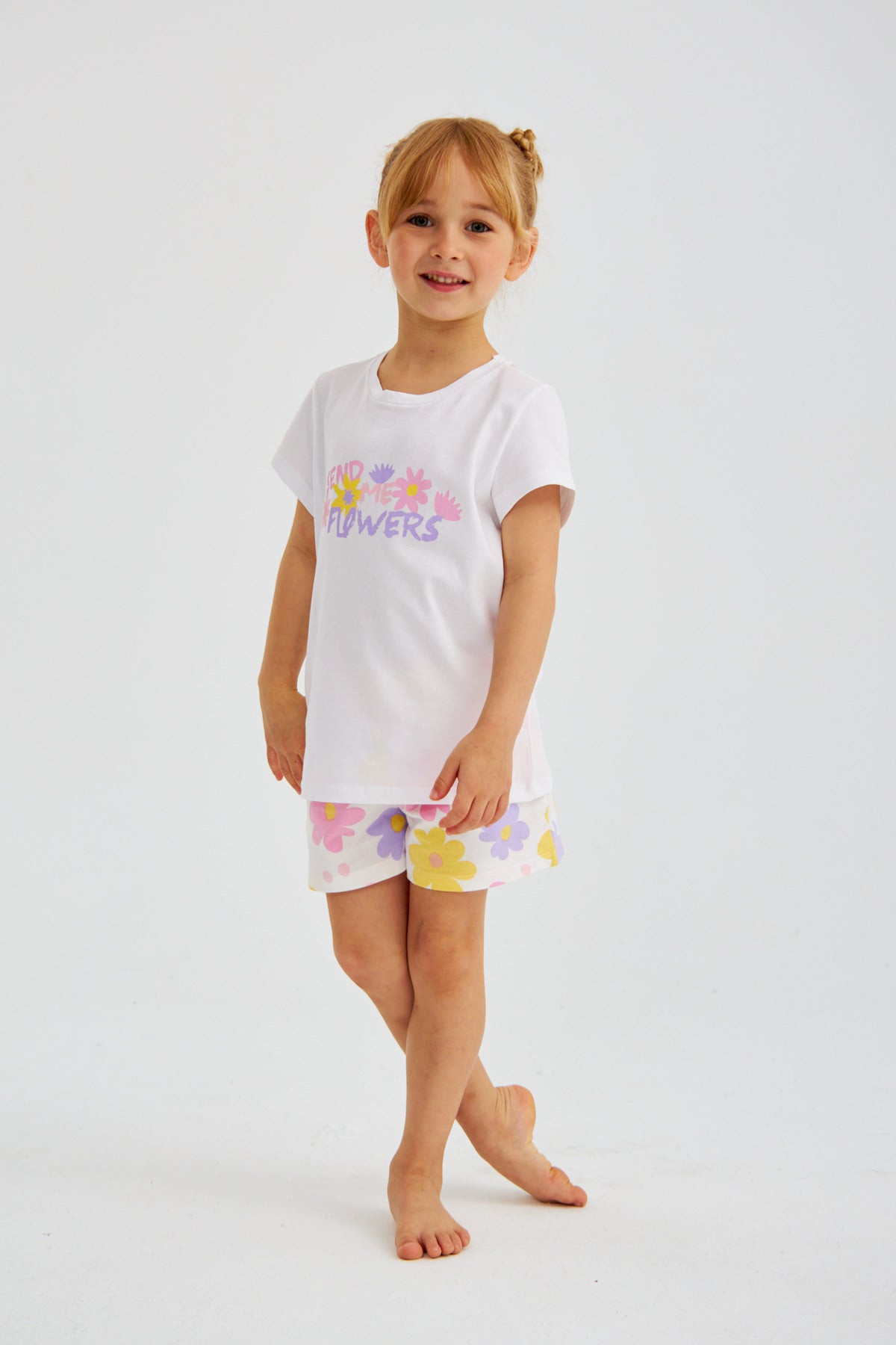 Young girl in the Popjammies "Send Me Flowers" pajama set, standing with one leg slightly bent.