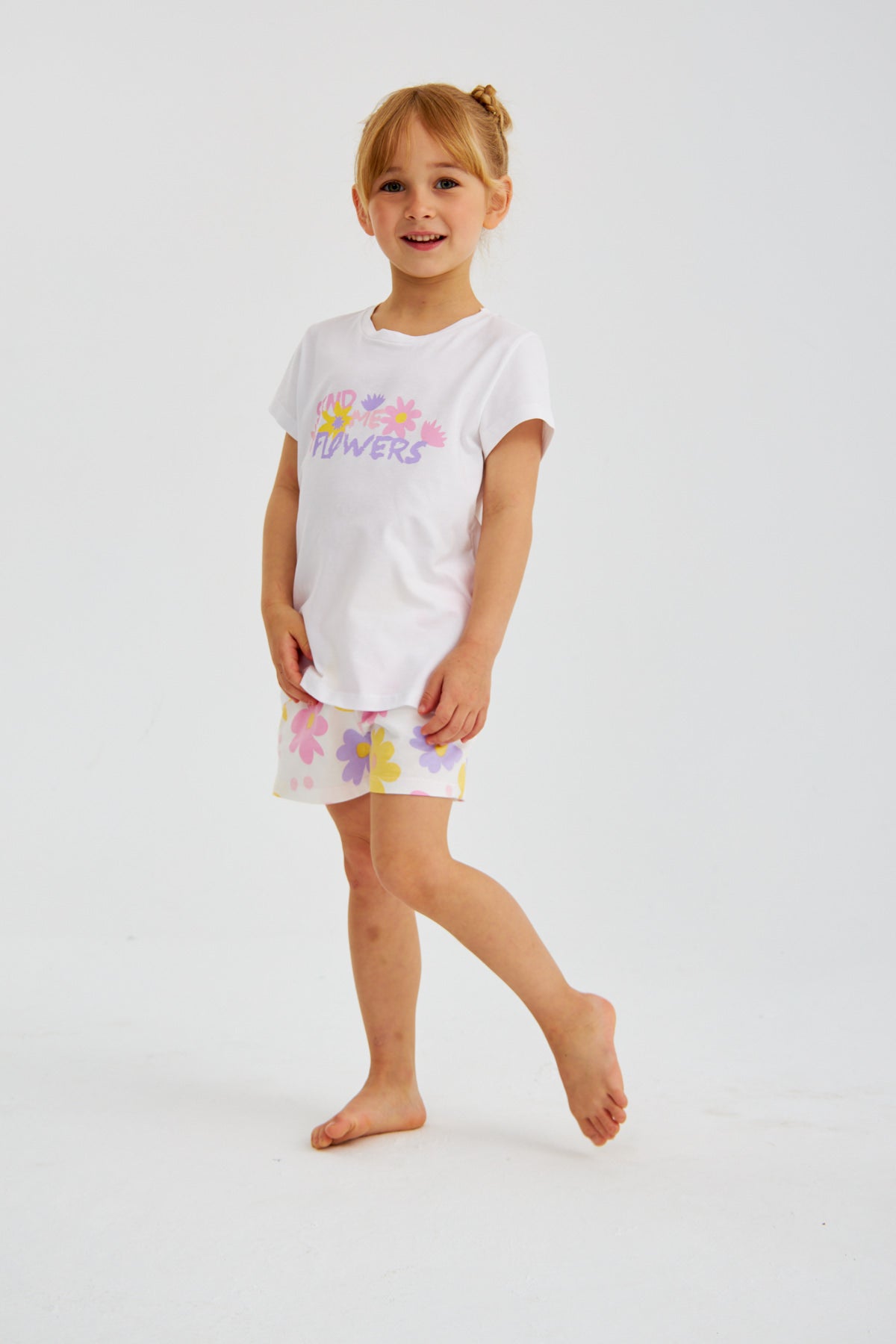 Young girl in the Popjammies "Send Me Flowers" pajama set, standing with one leg slightly bent.