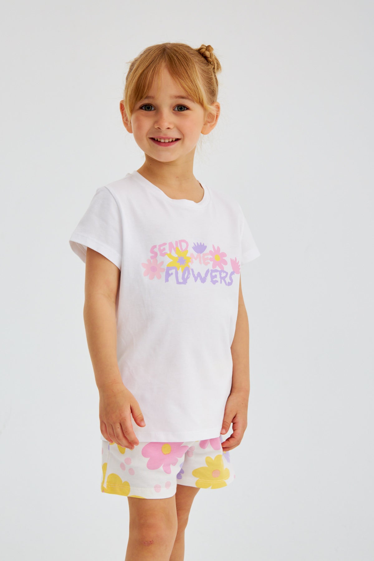 Young girl wearing the Popjammies "Send Me Flowers" pajama set, standing with a cheerful expression.