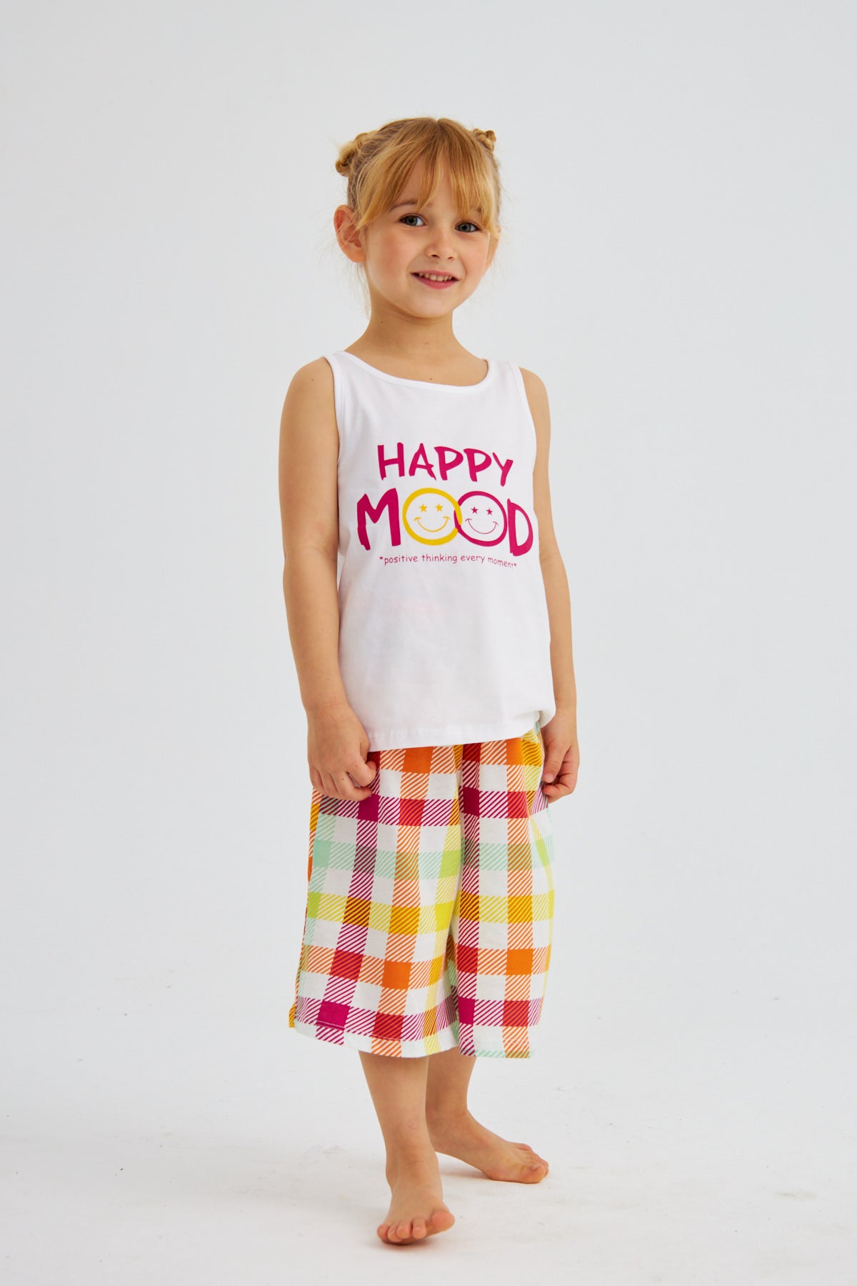 Little girl in "Happy Mood" pyjama set from Popjammies, standing and smiling.