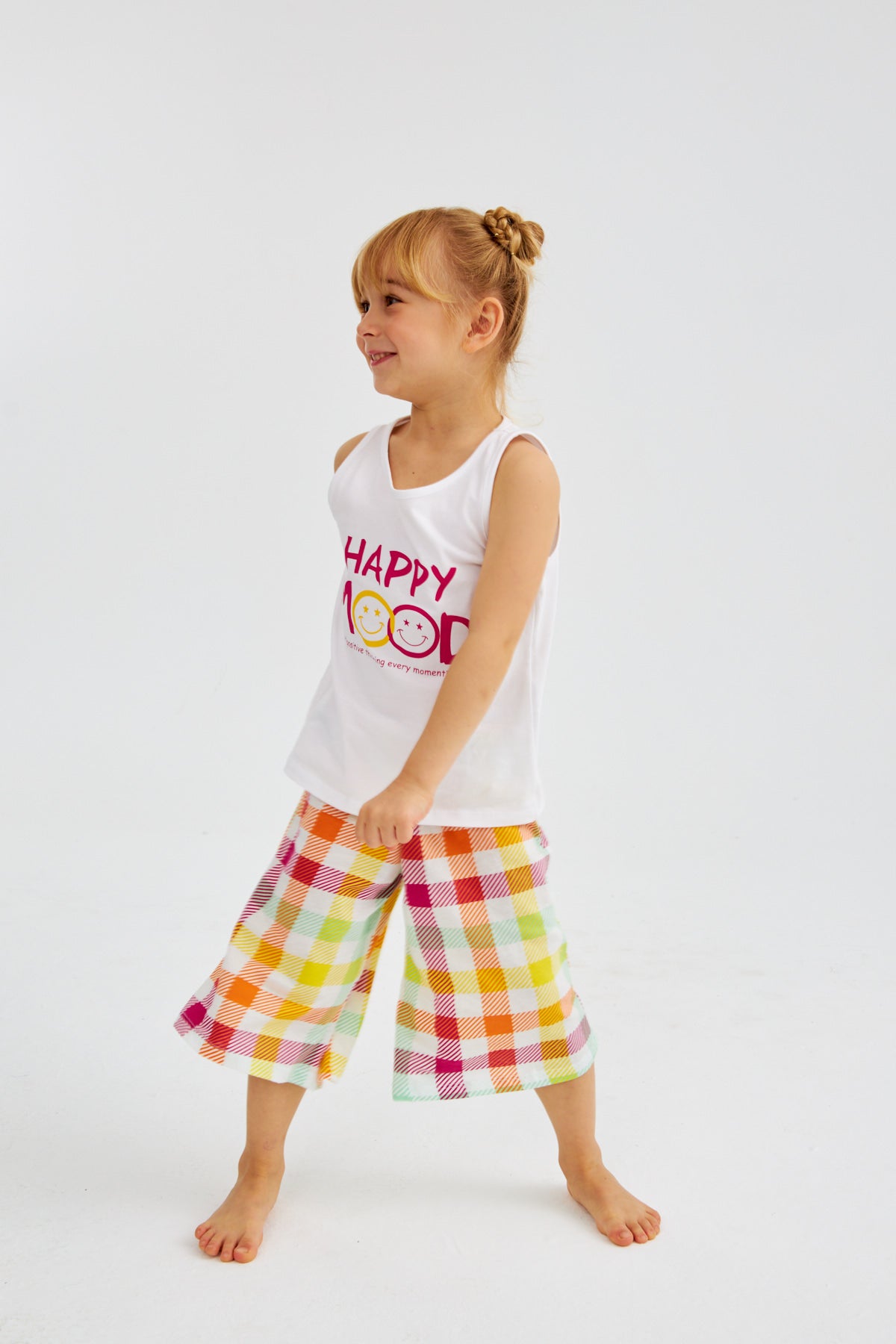 Little girl wearing "Happy Mood" pyjama set from Popjammies, striking a playful pose.