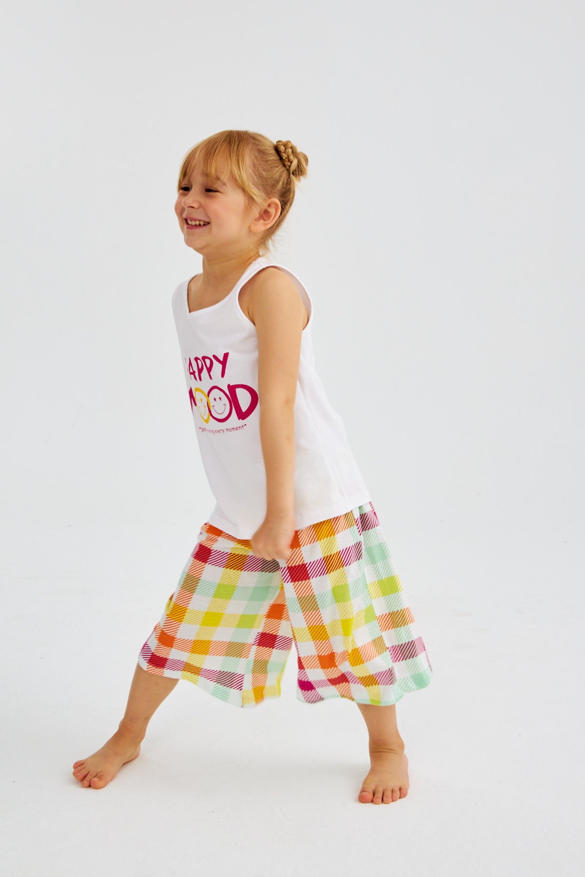 Little girl in "Happy Mood" pyjama set from Popjammies, dancing with a big smile.