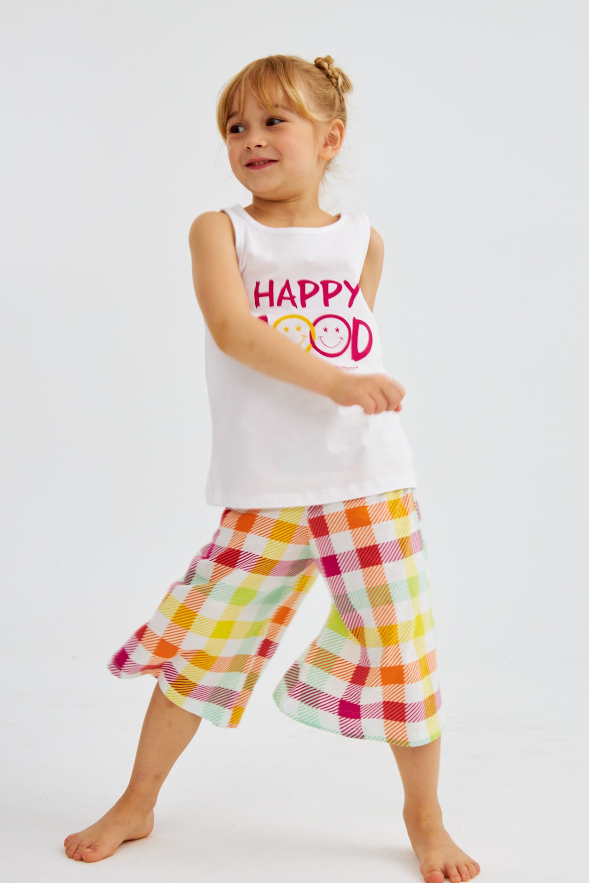 Little girl in "Happy Mood" pyjama set from Popjammies, smiling and playing.