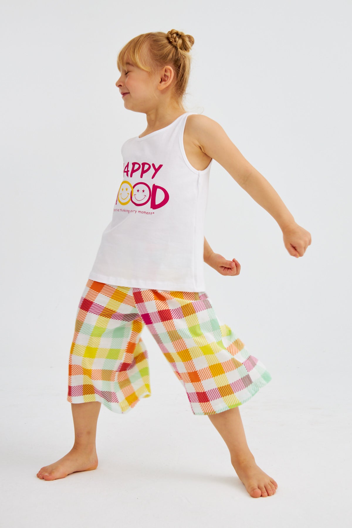 Little girl wearing "Happy Mood" pyjama set from Popjammies, striking a playful pose.