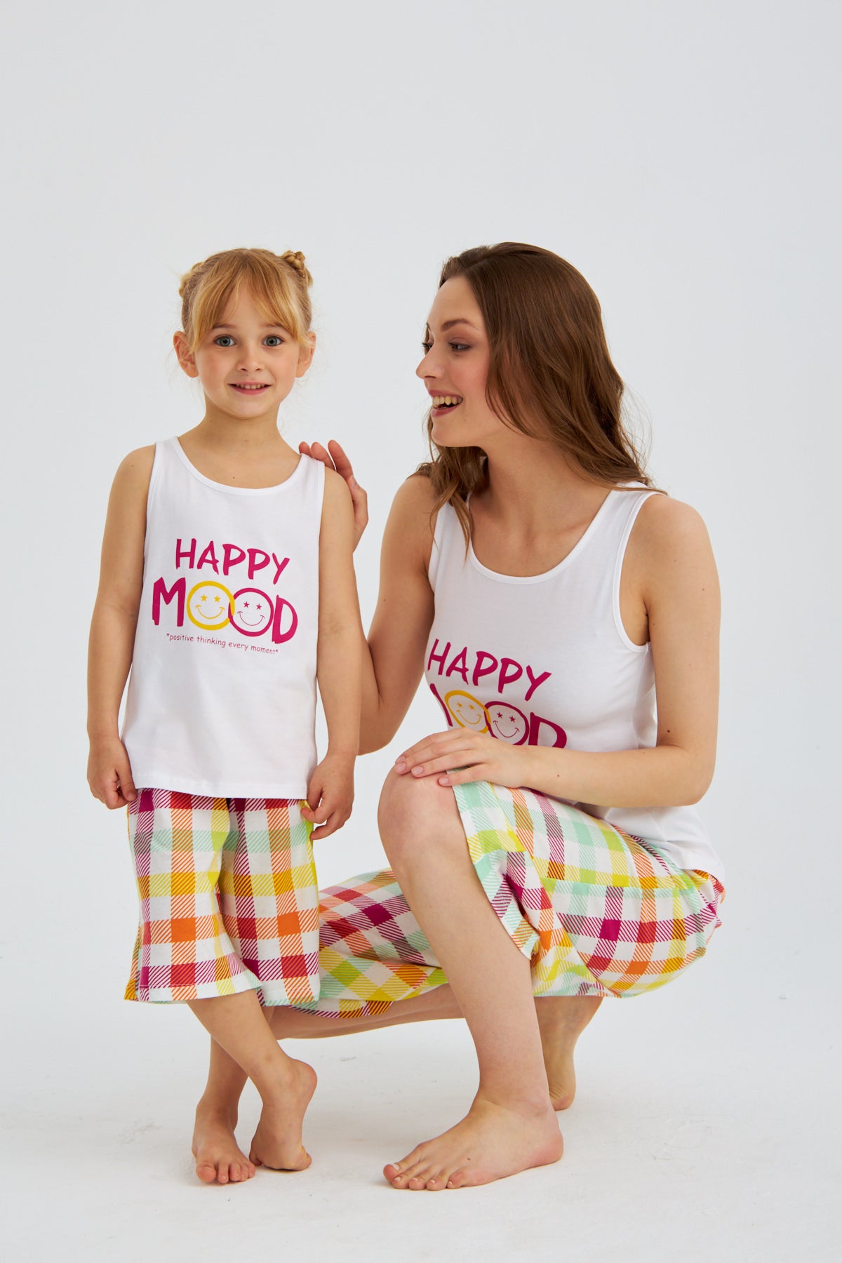 Mother and daughter wearing matching Happy Mood Checkered Pajama Sets by Popjammies, smiling and posing together.