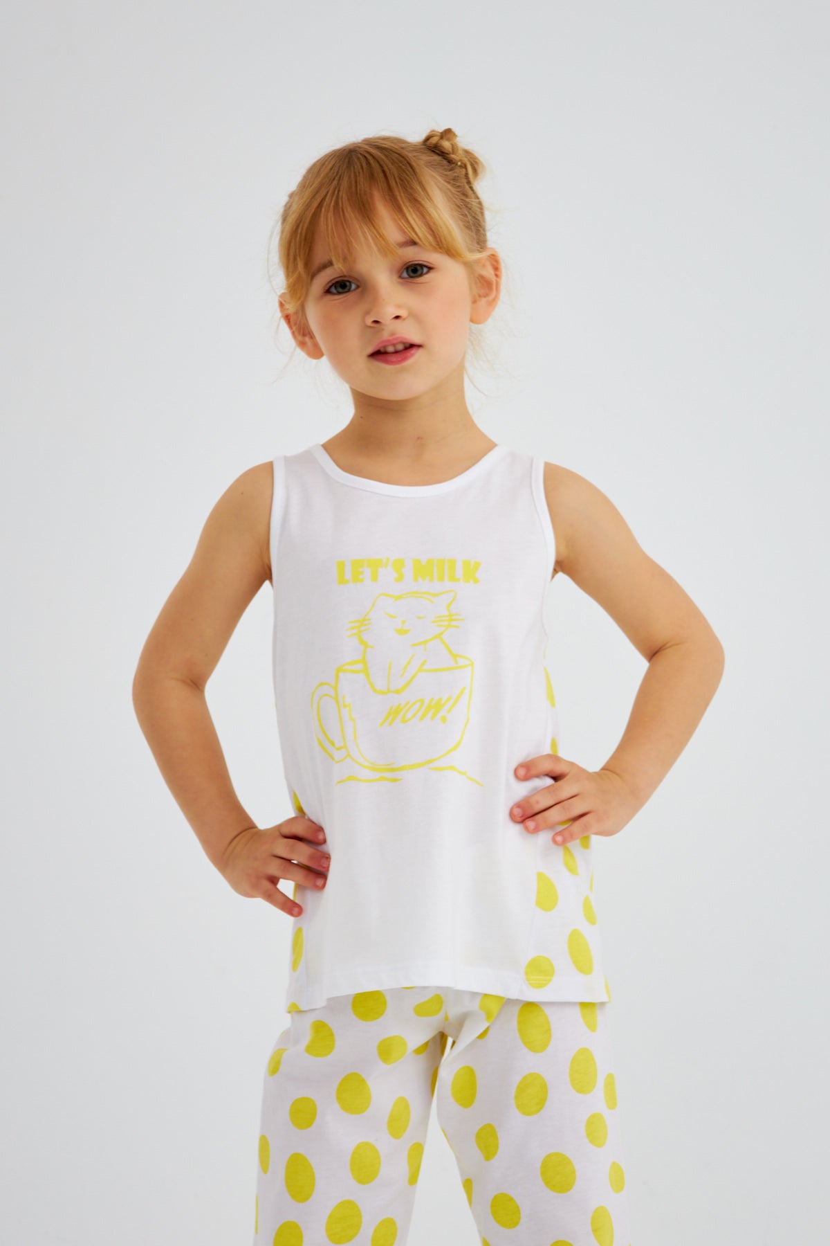 Little girl wearing Popjammies Let's Milk pyjama set, standing with hands on hips.