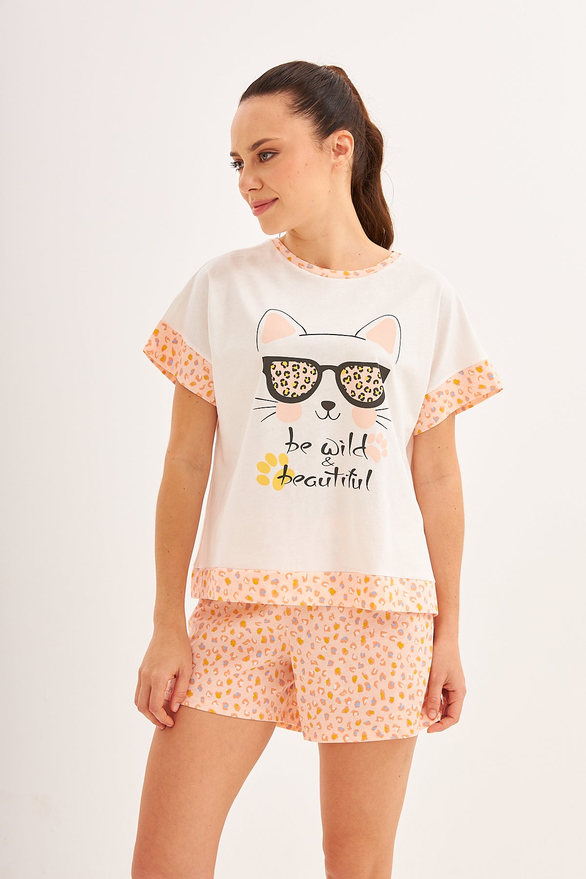 Close-up of mother wearing Popjammies pyjama set with cat-themed top and leopard print shorts.