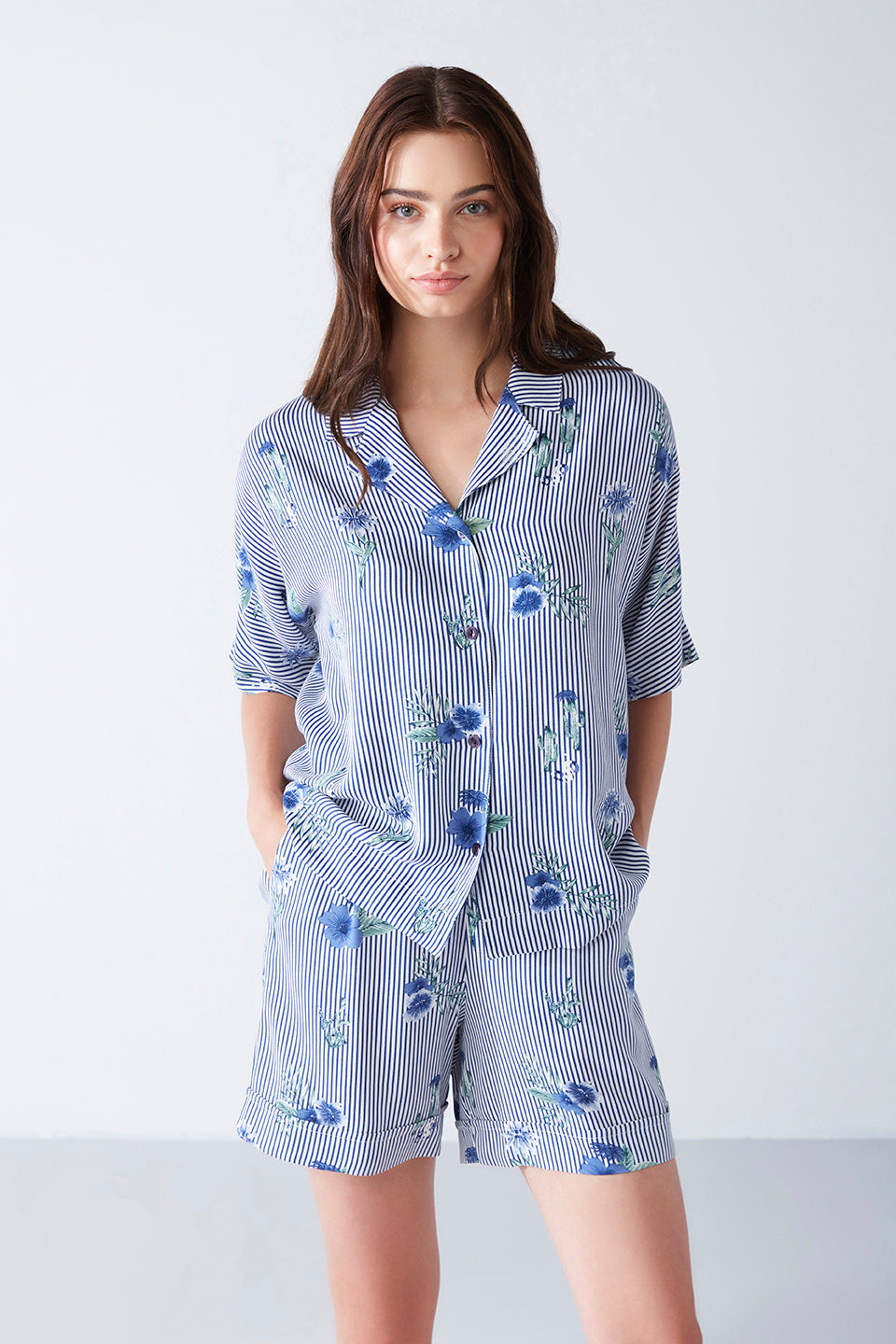 Front view of a woman in a blue striped floral print pyjama set from Popjammies, perfect for elegant loungewear.