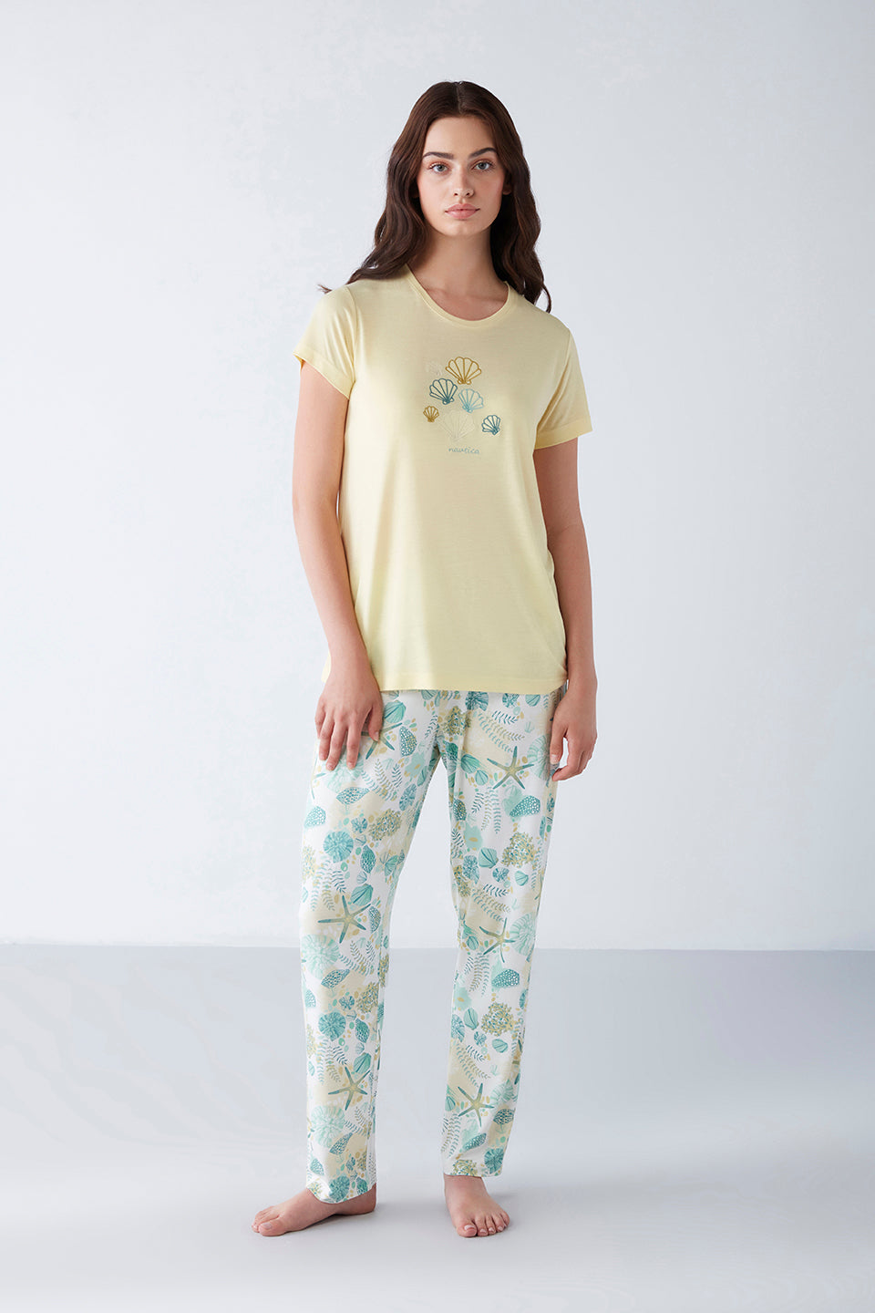 Model wearing Popjammies Women's Pyjama Set with a yellow top featuring shell designs and printed pants.