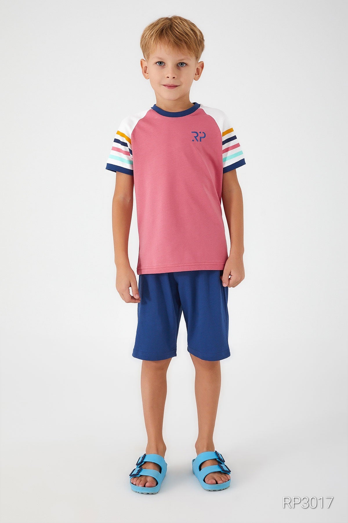 Boy wearing Popjammies pink top with 'RP' and blue shorts, front view.