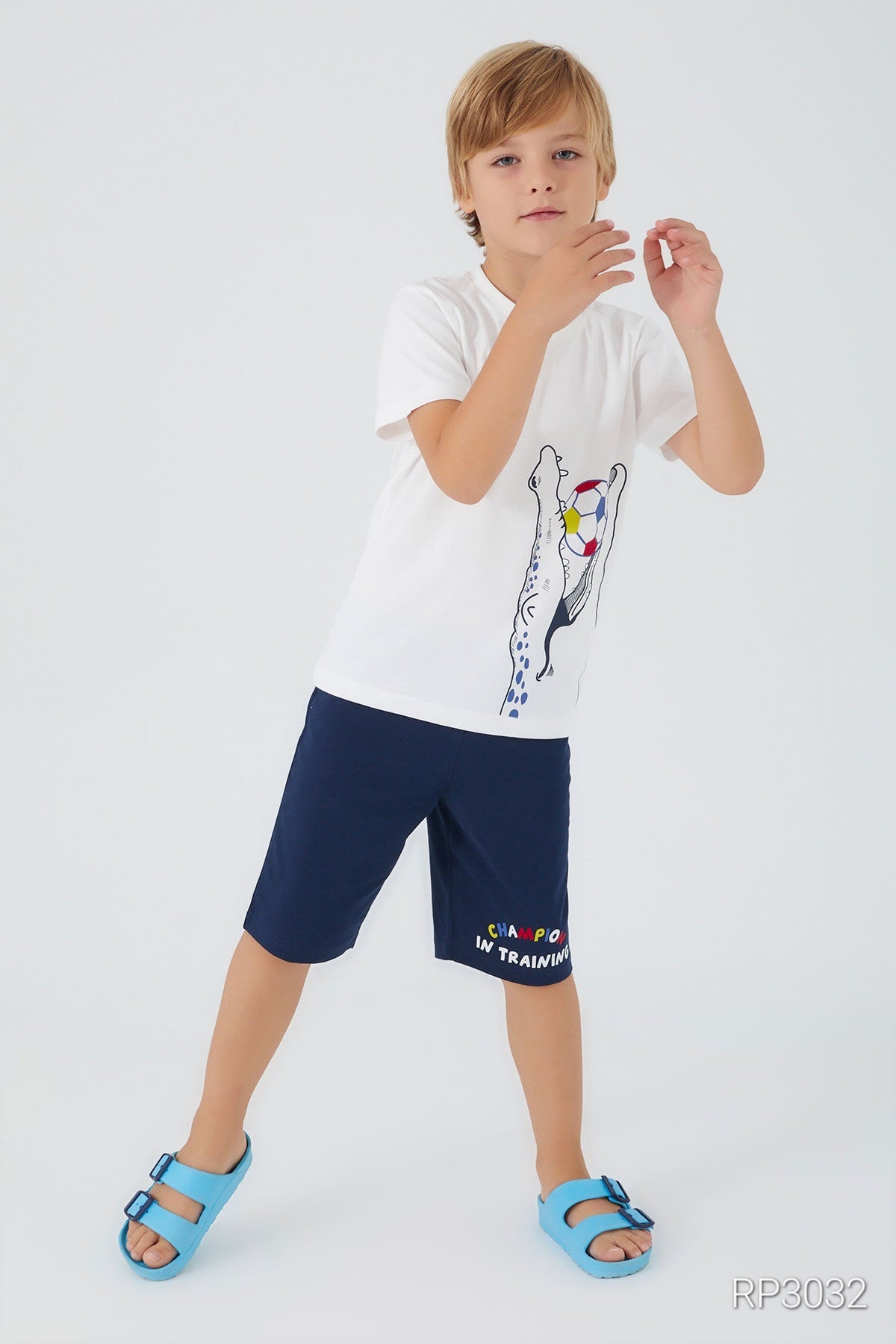 Full view of Popjammies boys' pyjama set with a white top and navy shorts, showcasing a crocodile holding a multicolor ball design.