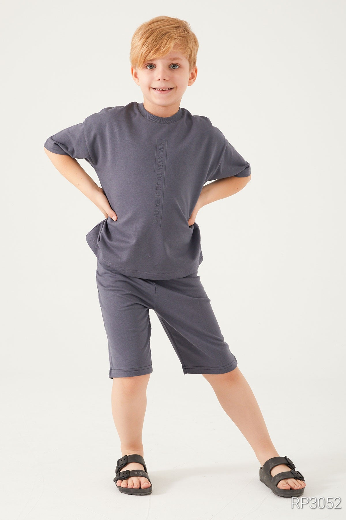 Boy posing with hands on his hips wearing Cozy Dreams Boys' Grey Matching Pyjama Set in ultra-soft cotton, featuring a short-sleeved top and matching shorts.