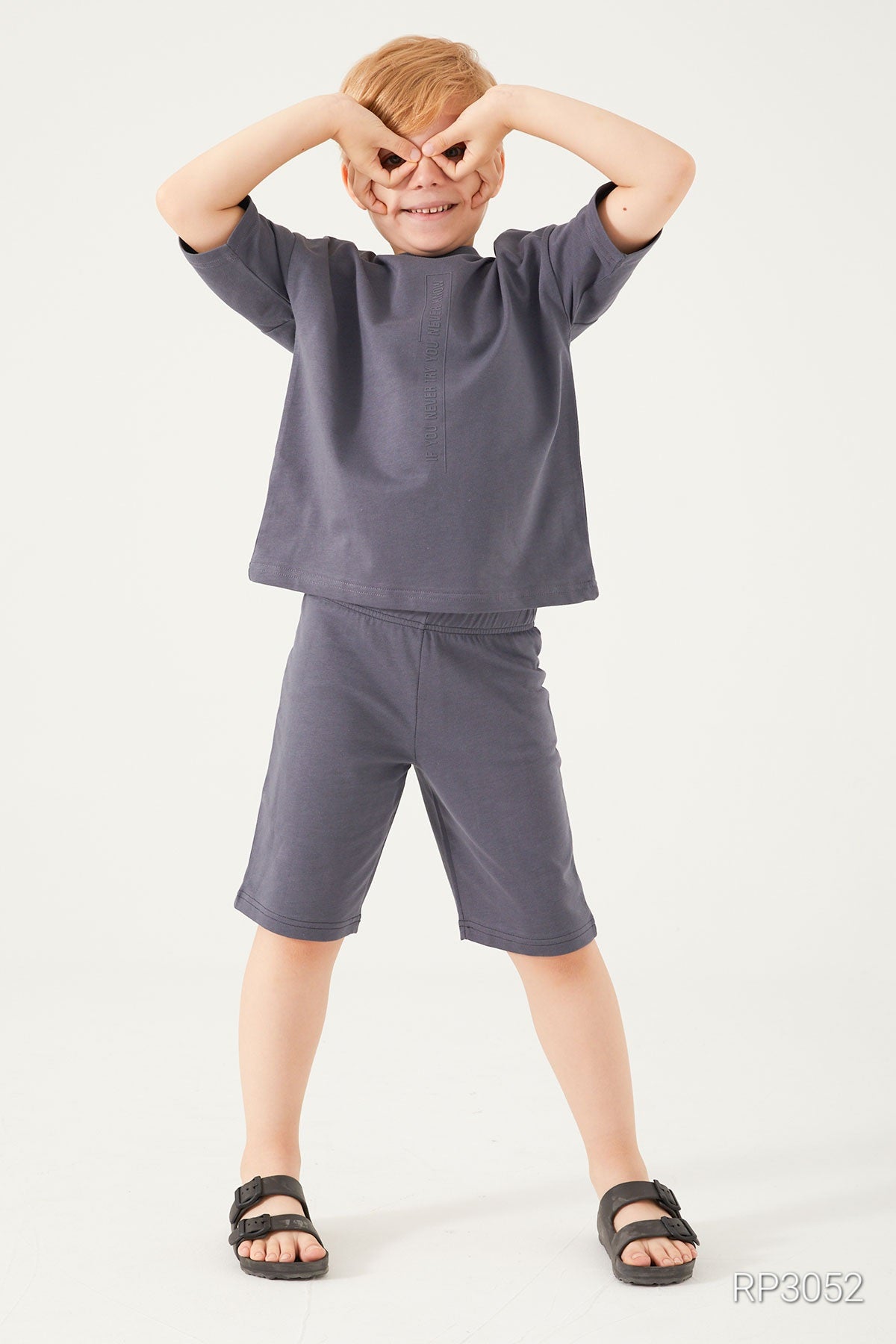 Boy with hands on his eyes wearing Cozy Dreams Boys' Grey Matching Pyjama Set in ultra-soft cotton, featuring a short-sleeved top and matching shorts.