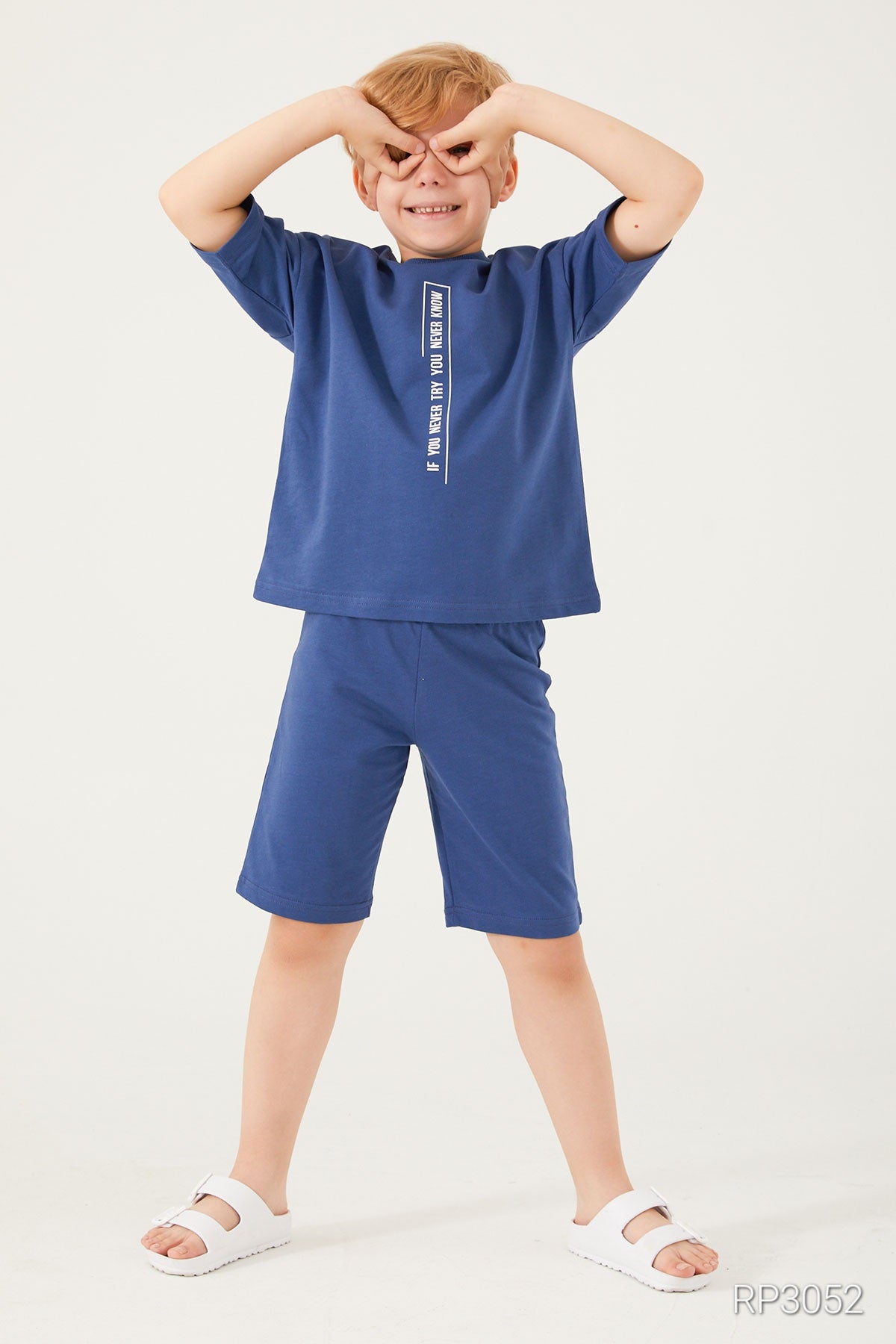 Boy putting his hands on his eyes and wearing blue matching set