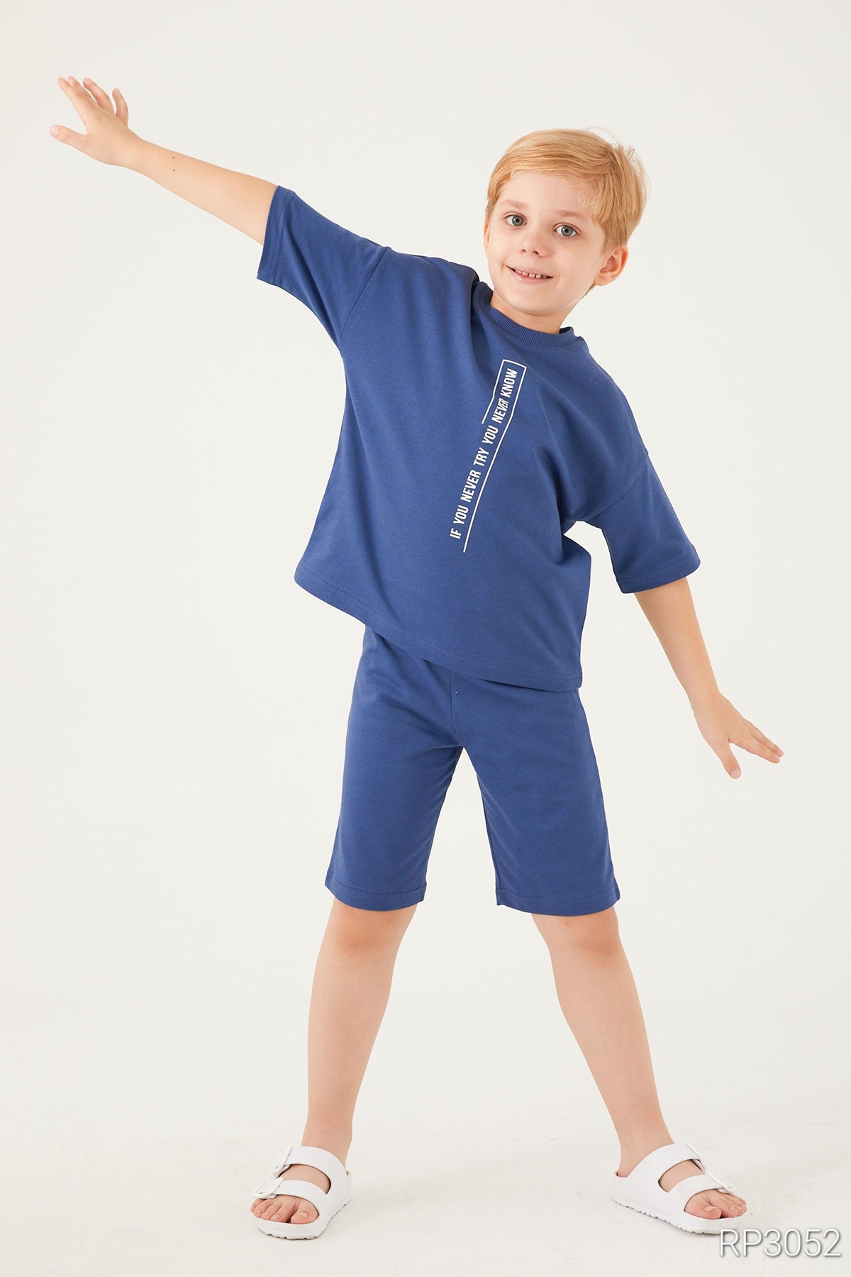 Boy opening his hands and wearing the blue matching set