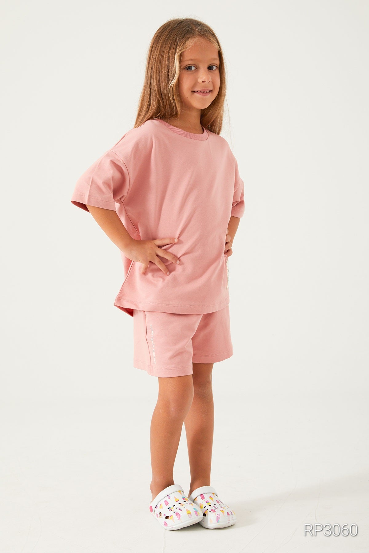 Side view of Popjammies Cozy Cotton Light Pink Matching Set for Girls highlighting the short sleeves and elastic waistband on the shorts.