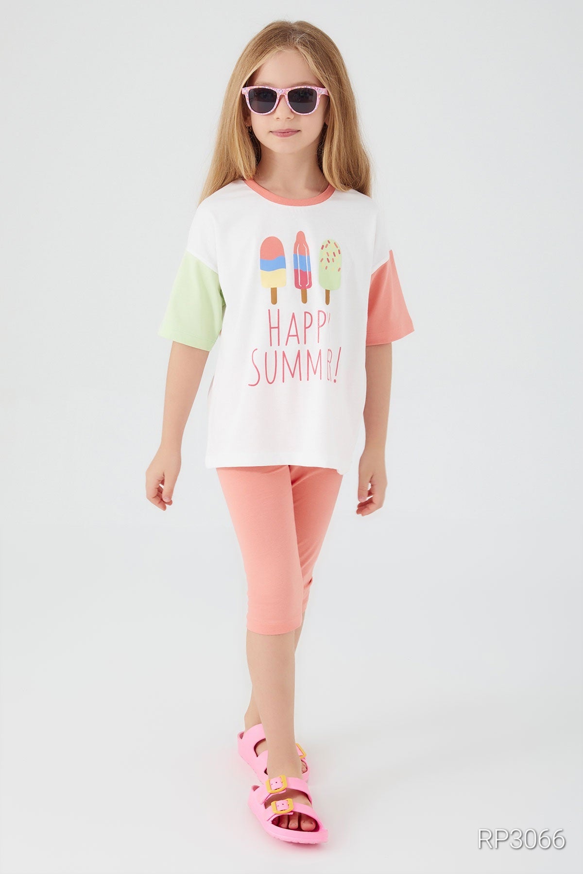 Front view of Popjammies 'Happy Summer' Pajama Set featuring a white top with 'Happy Summer' text and ice cream graphic, with one pastel sleeve and one light green sleeve, paired with pastel pantacour pants wearing sunglasses