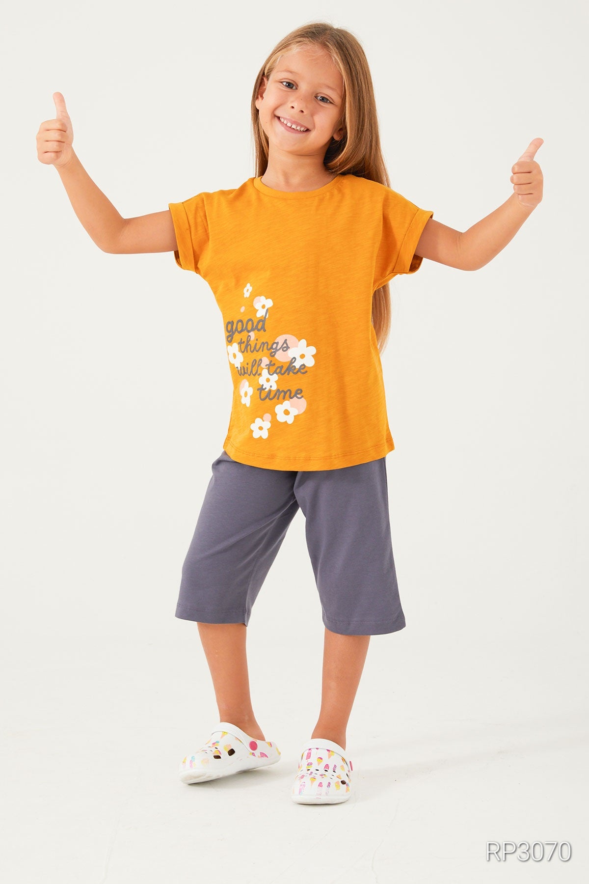  Girl wearing Popjammies Timeless Blooms Pajama Set with mustard top and navy pantacour, happy