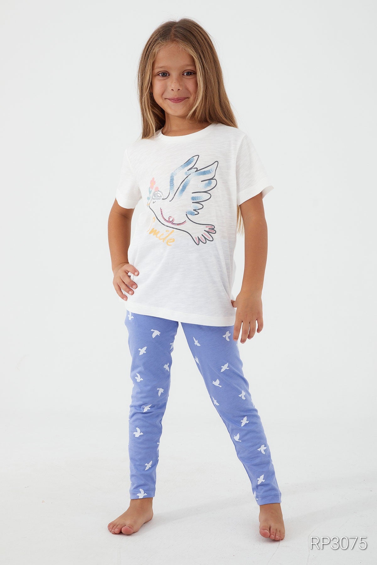 Girl wearing Popjammies Birdie Bliss Pajama Set with white top and blue pants posing with one hand on her hips