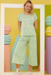 Model wearing Popjammies mint green pajama set with 'It's all going to be okay' message and daisy print pants