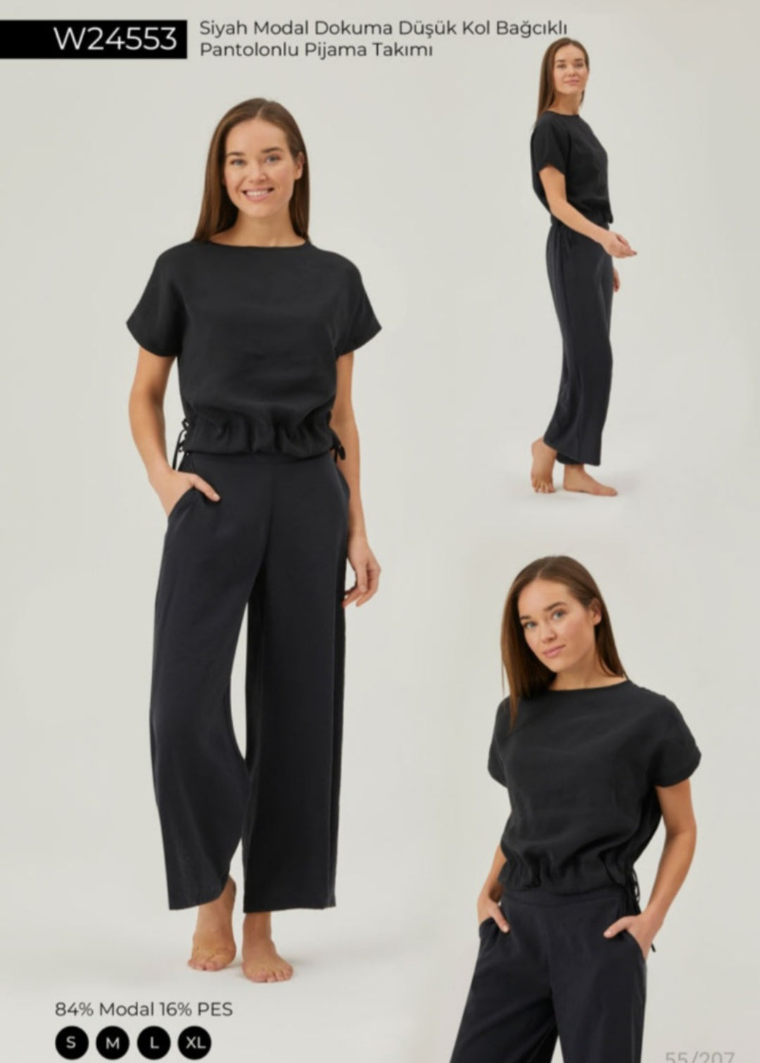 Model wearing Popjammies Black Drawstring Waist Pyjama Set, featuring a relaxed top with adjustable drawstring sides and wide-leg trousers made from a soft modal blend.