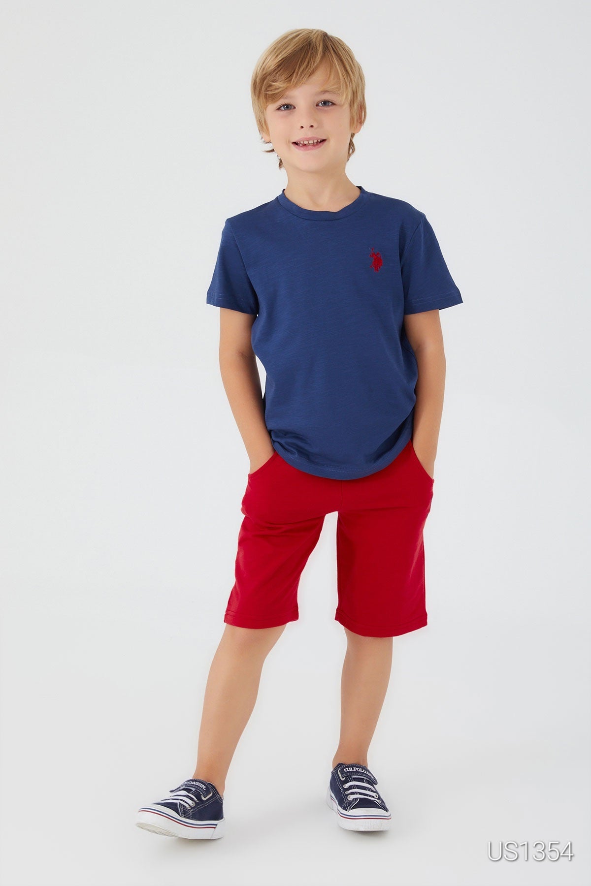  A young boy wearing a navy top with bold red "USPA" lettering and matching red shorts.