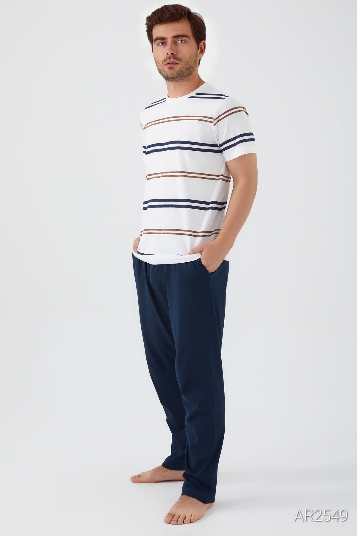 Profile view of a man in Popjammies white striped top and blue pants, showcasing the outfit's relaxed fit and stylish appearance.