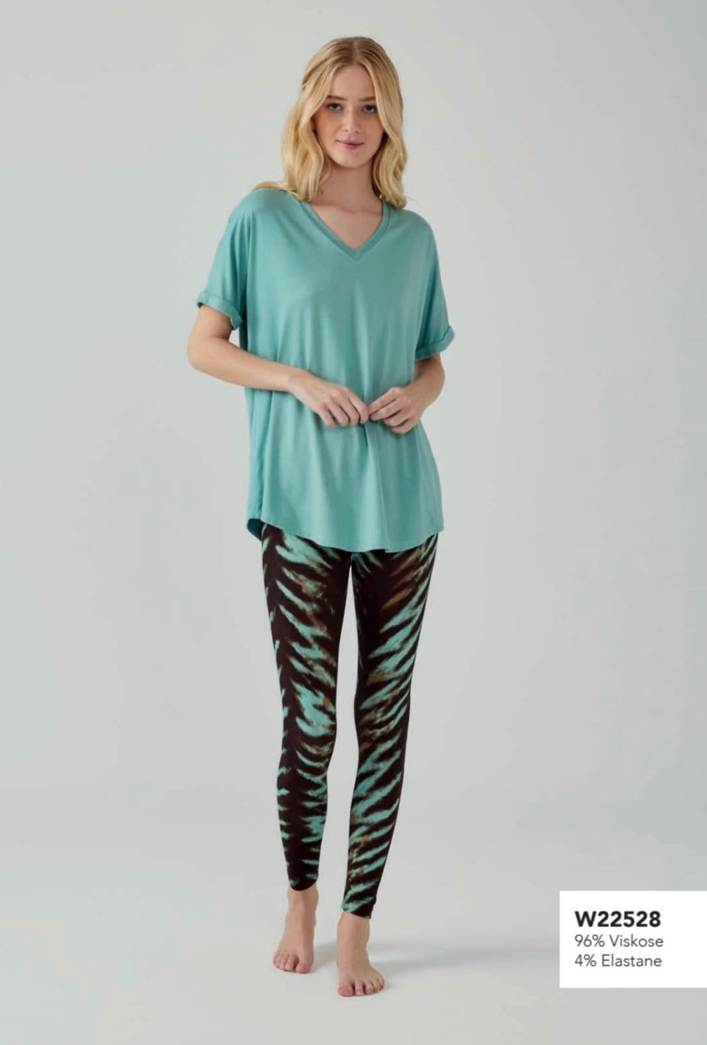 Model wearing Popjammies teal V-neck pyjama set with black and teal zebra-print leggings, standing against a plain background.