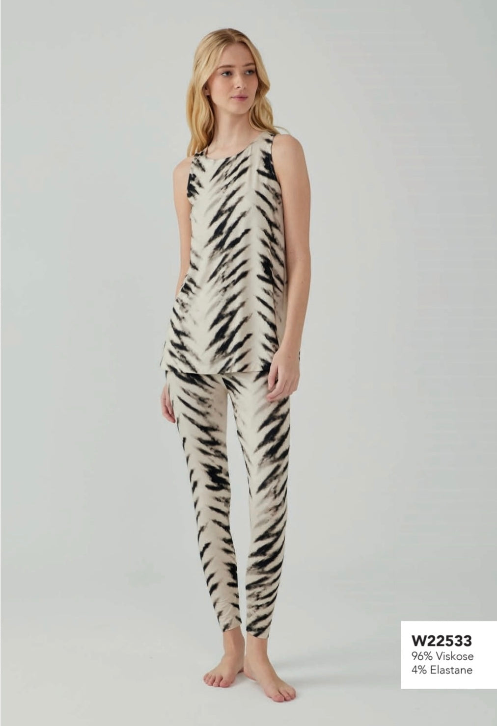 Model wearing Popjammies zebra-print sleeveless pyjama set with a beige and black pattern, standing against a plain background.