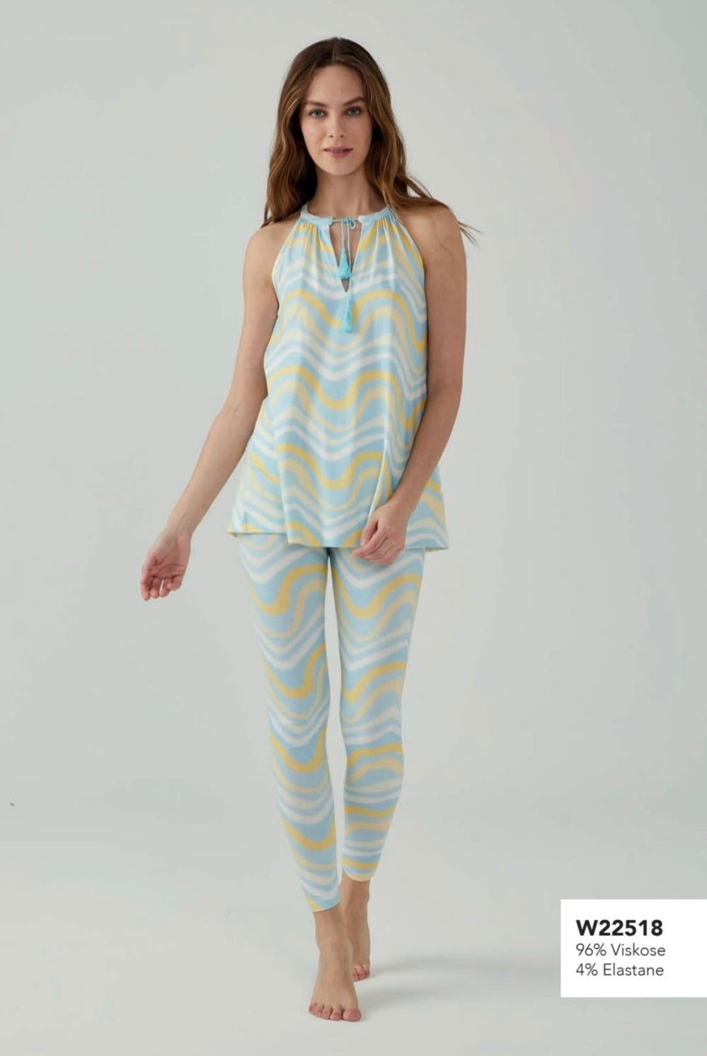 Model wearing Popjammies sleeveless pyjama set with pastel blue and yellow wave pattern, standing against a plain background.