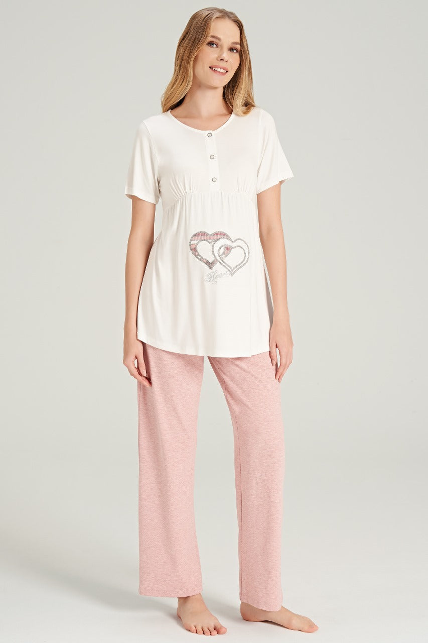 Woman in Popjammies maternity pajama set with pink pants and white top featuring heart design.