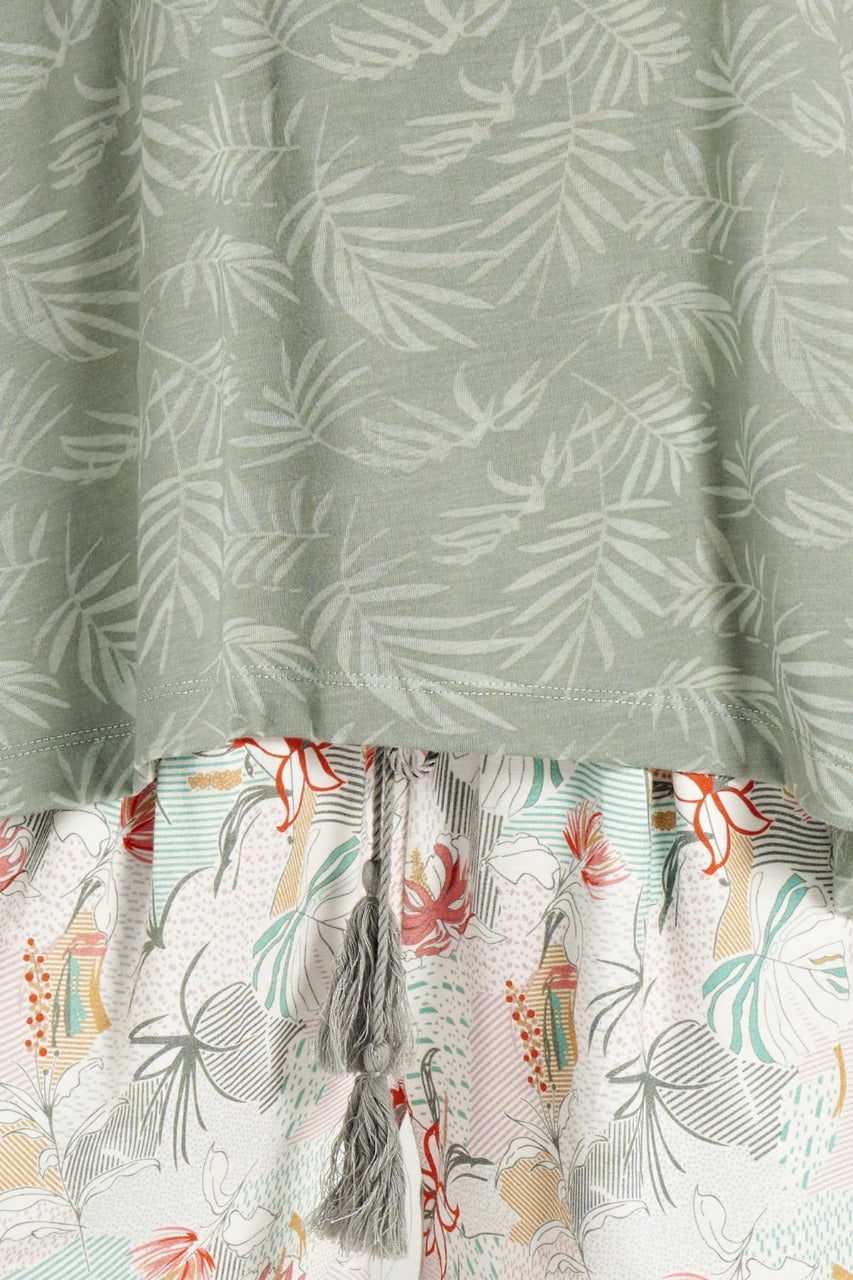 Close-up of the fabric pattern on a green tank top and floral print shorts pajama set.