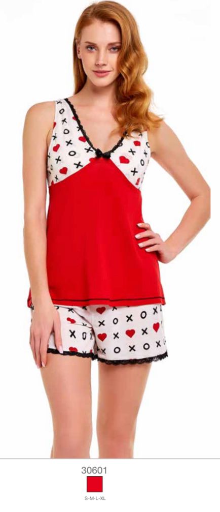 Woman wearing a red and white pyjama set with XO and heart pattern, featuring a sleeveless top and matching shorts from Popjammies.